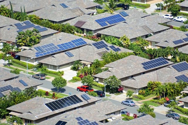 Aerial view of a neighborhood with solar panels on many rooftops