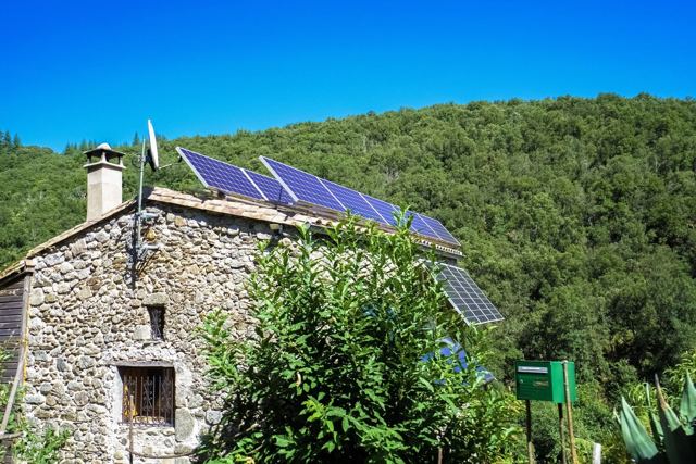 Solar panels on the pitched shingle roof of a house